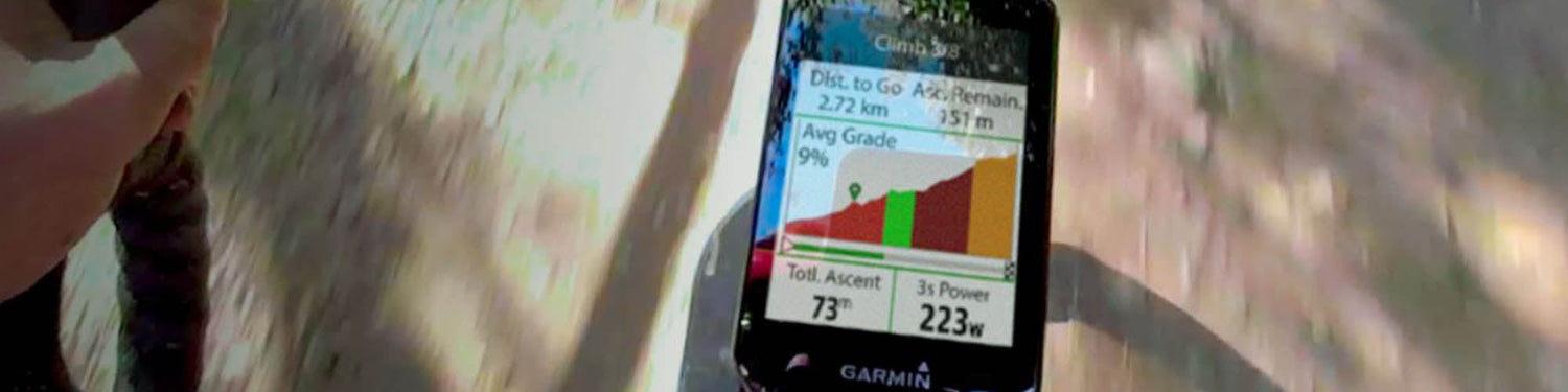 Image of a Garmin GPS bike computer attached to a bike stem, which the shadow of the road and a bike underneath.