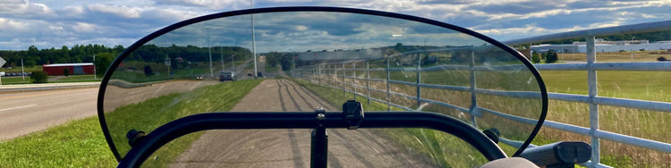 A view through a trike fairing going down the bike path.