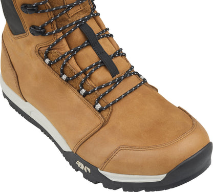 Studio above view of toe box area of a brown leather boot with a black and white sole and laces.