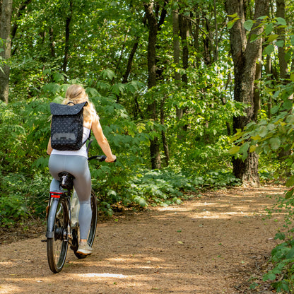 Po Campo Atria Backpack Black City Lights being used as backpack while riding a bike, outdoor image