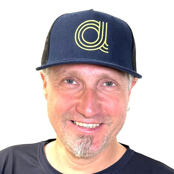 Front view of a man wearing an Azub Baseball Hat Dark Blue with lime  green "A" logo .
