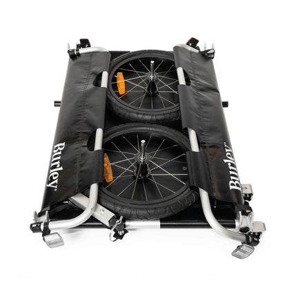 Side view of the Burley Flatbed Cargo Trailer, shown folded with the wheels removed, on a white background.