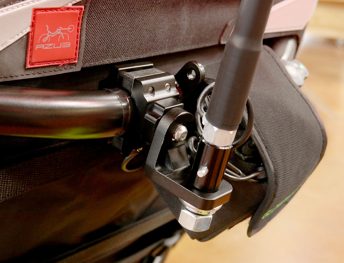 Close up view of the black metal 360 degree flag mount on the back of a recumbent trike.