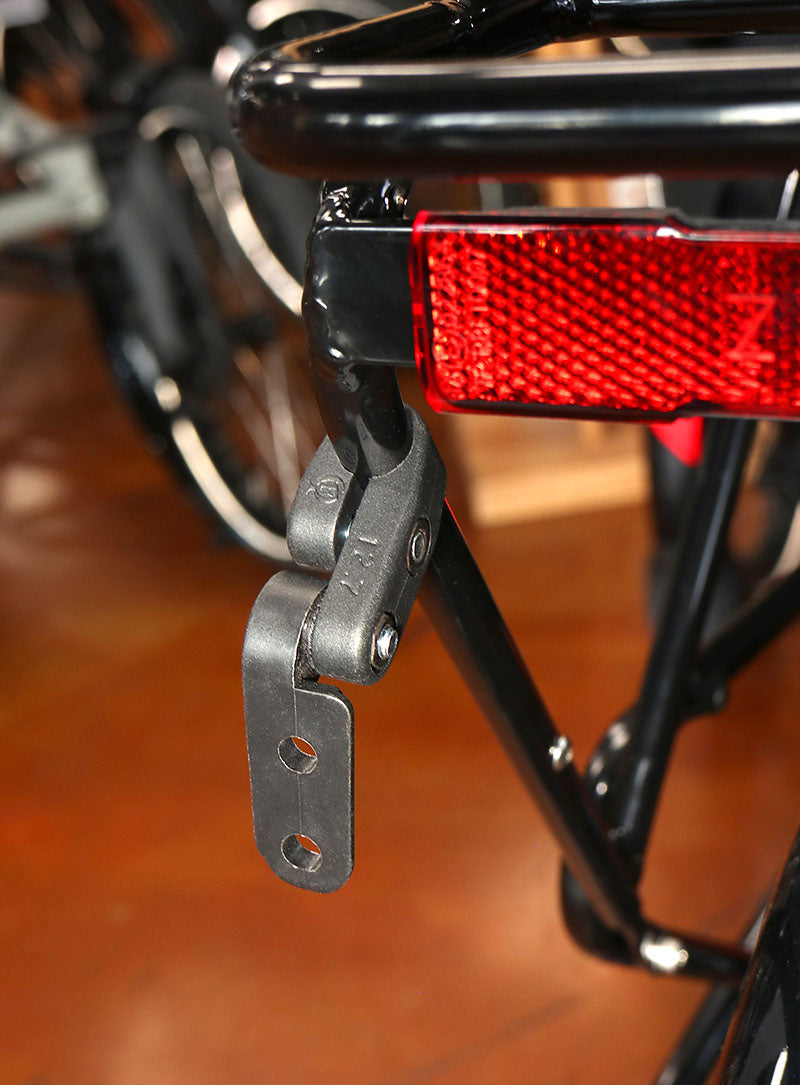 Black plastic light mount installed on a black bicycle rack.
