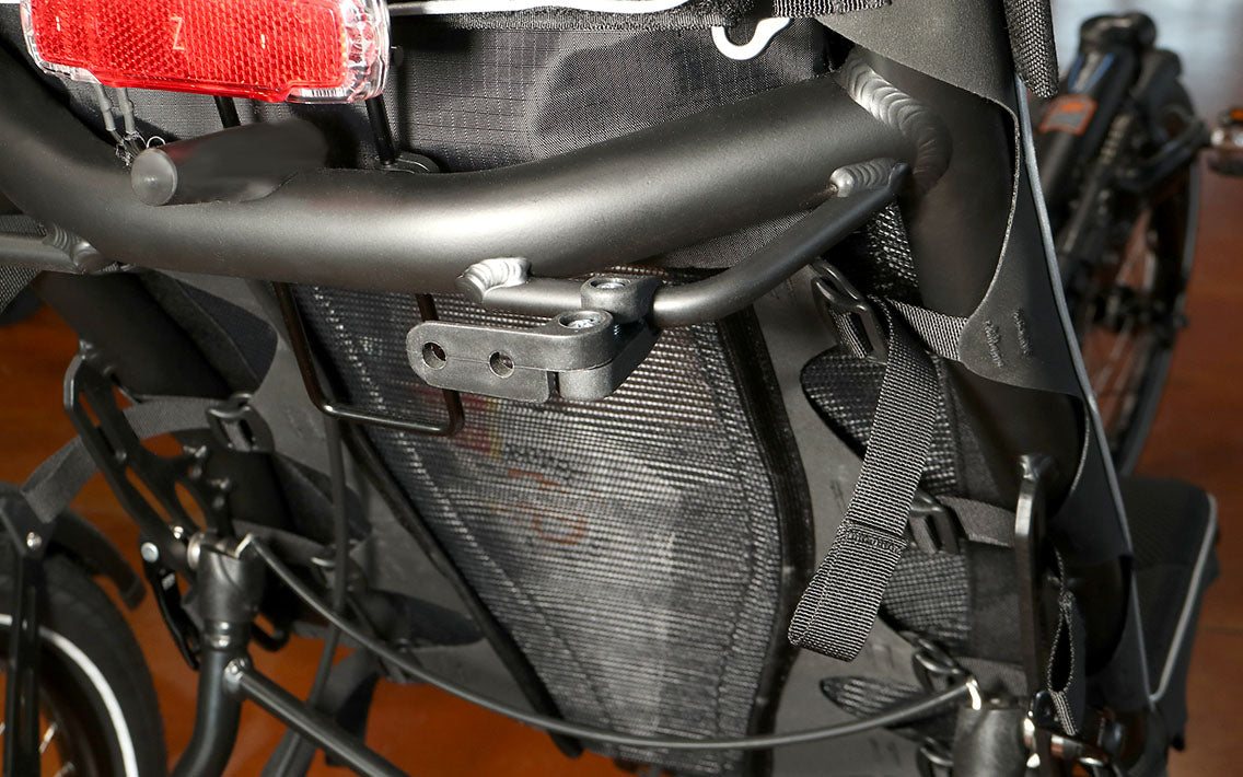 Black plastic light mount installed on the back of a recumbent trike seat.