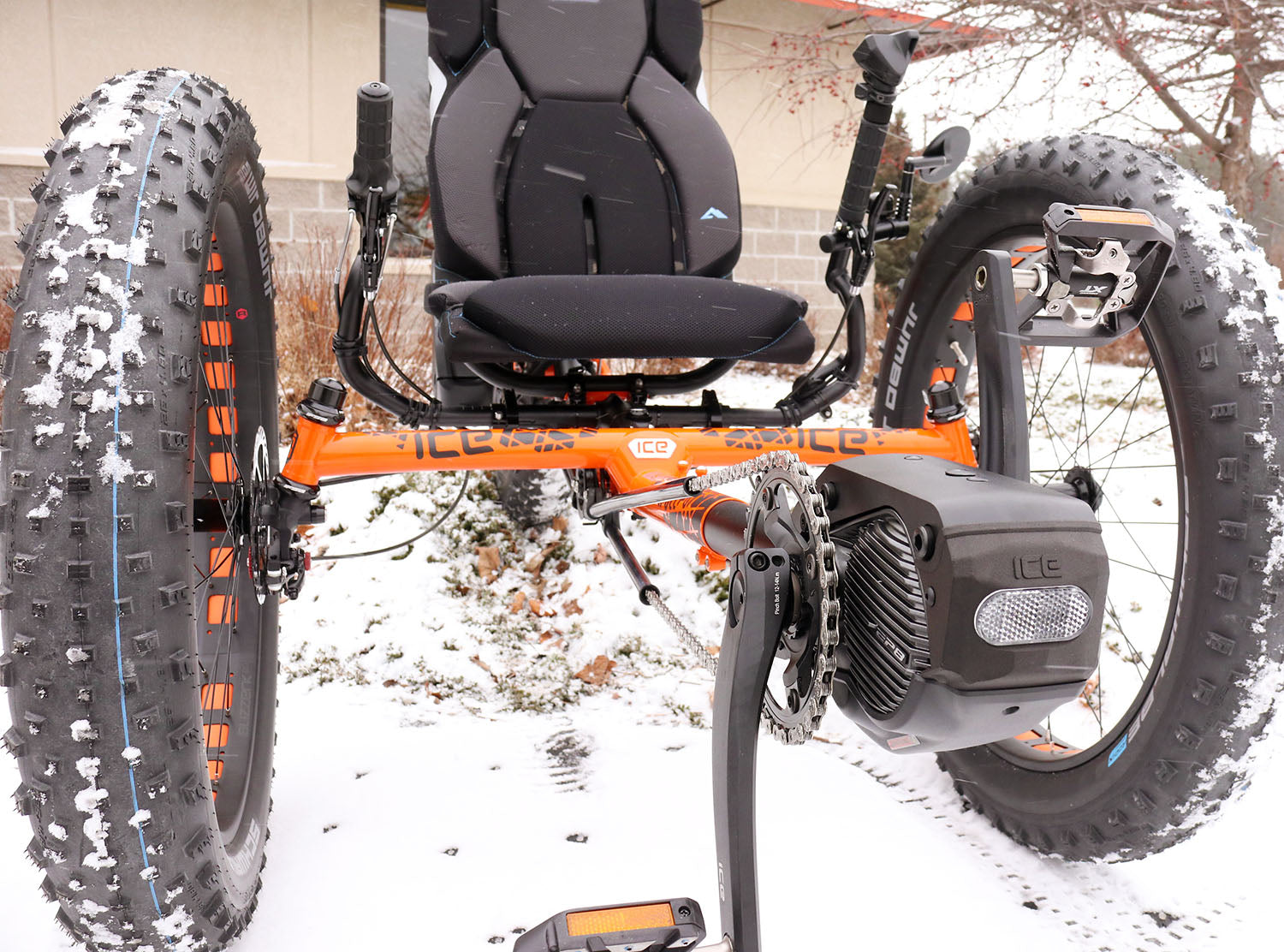 Front view of ICE Full Fat recumbent trike depicting Shimano motor and orange frame. 