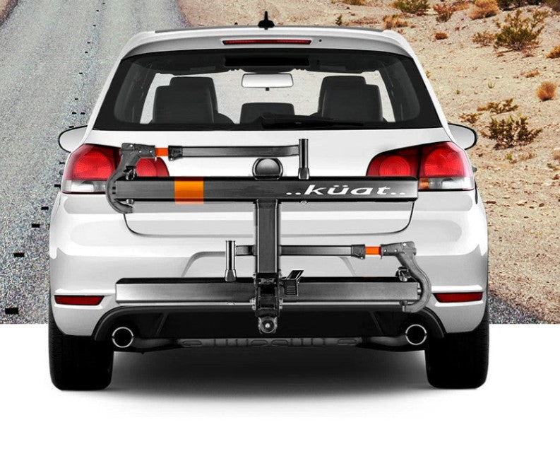 Kuat Sherpa 2.0 - 2" - 2-Bike Rack - Gray Metallic and Orange Anodize Image with road in the background