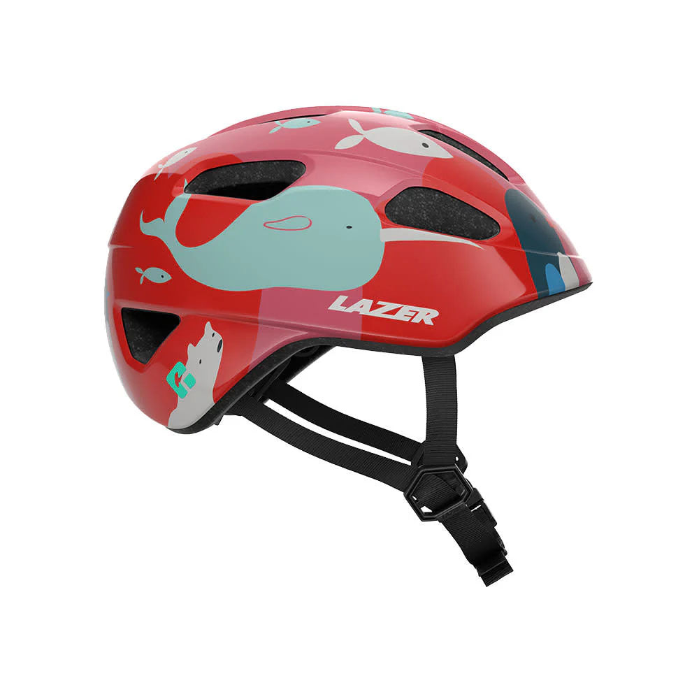Profile studio view of a toddler sized bicycle helmet with red background  with white polar bears, mint narwhals, dark blue whales, and white fish scattered throuhgout.