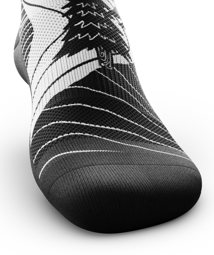 Black toe area of black and white socks with mountain and forest scene