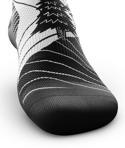 Black toe area of black and white socks with mountain and forest scene