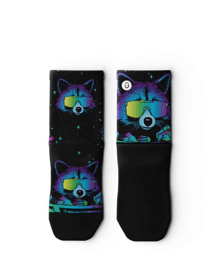 Pair of black sock laying flat with heads of racoons wearing sunglasses and garbage cands.  Racoons and garbage cans are blues, purples, teals, and yellows, background is black.