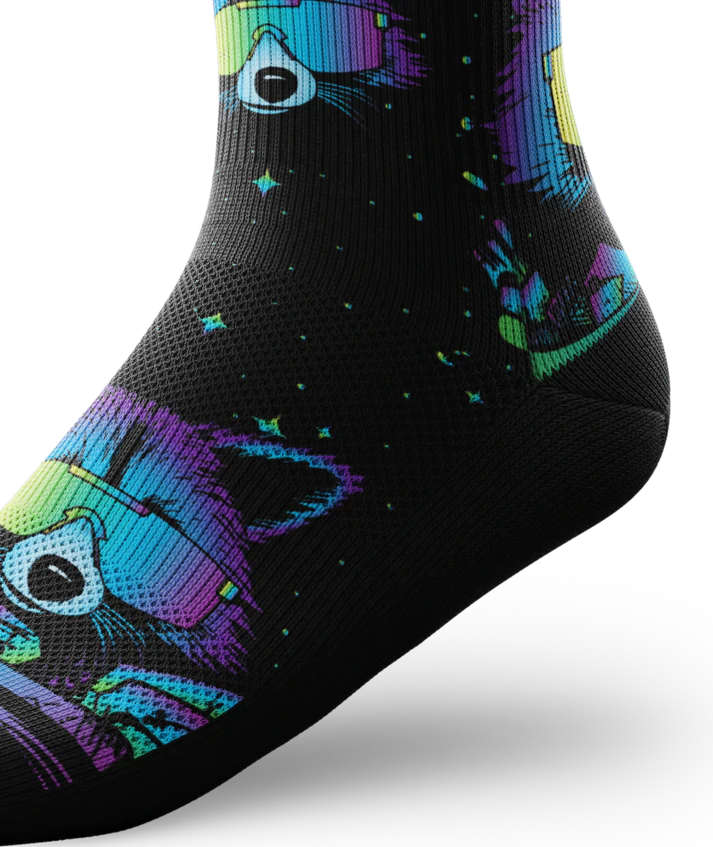 Ankle view of a black sock with heads of racoons wearing sunglasses and garbage cands.  Racoons and garbage cans are blues, purples, teals, and yellows, background is black.