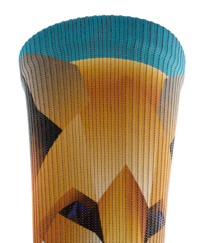 Top cuff of multicolored sock with geometric sock head. Background of sock is teal blue 