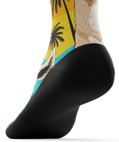 Bottom black sole of sock with with ocean sunset, black palm trees, and heads of llamas on main part of sock.