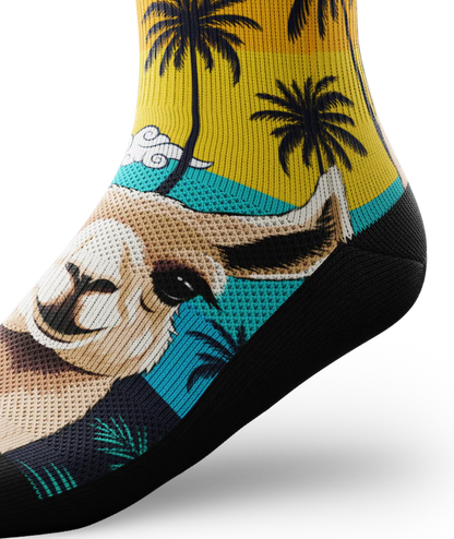 Side ankle view of  asock with with ocean sunset, black palm trees, and heads of llamas on main part of sock.