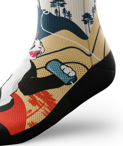 Ankle side view of multicolored socks with black and white cat talking into a can connected with a string to another calico cat.  Asian inspired background of trees and sun. Black soles