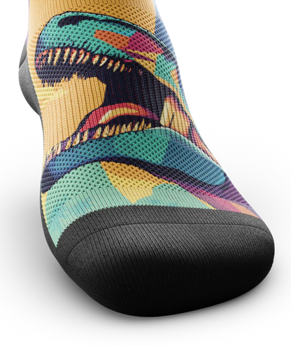 Top toe area of Multicolored sock with T-rex dinosaurs and palm trees on main part of sock, black soles. 