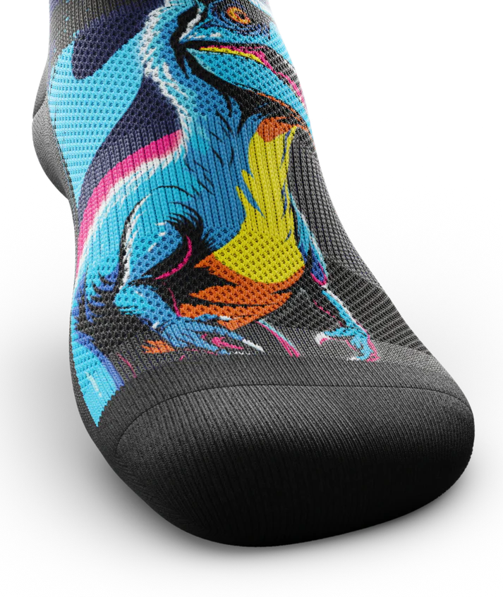 Top toe area of sock with blue yellow and orange velociraptor across top of sock .  Toe and sole are black. 