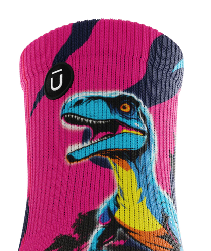 Top cuff of multicolored pink, blue and black pair of socks with velociraptors, and black trees. Small black circular patch with Outway logo on top third of cuff. 