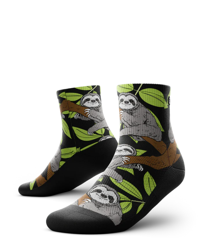 Pair of socks with grey sloths in trees with black background and soles