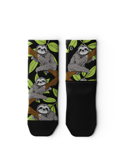 Pair of socks laying flat with grey sloths in trees with black background and soles