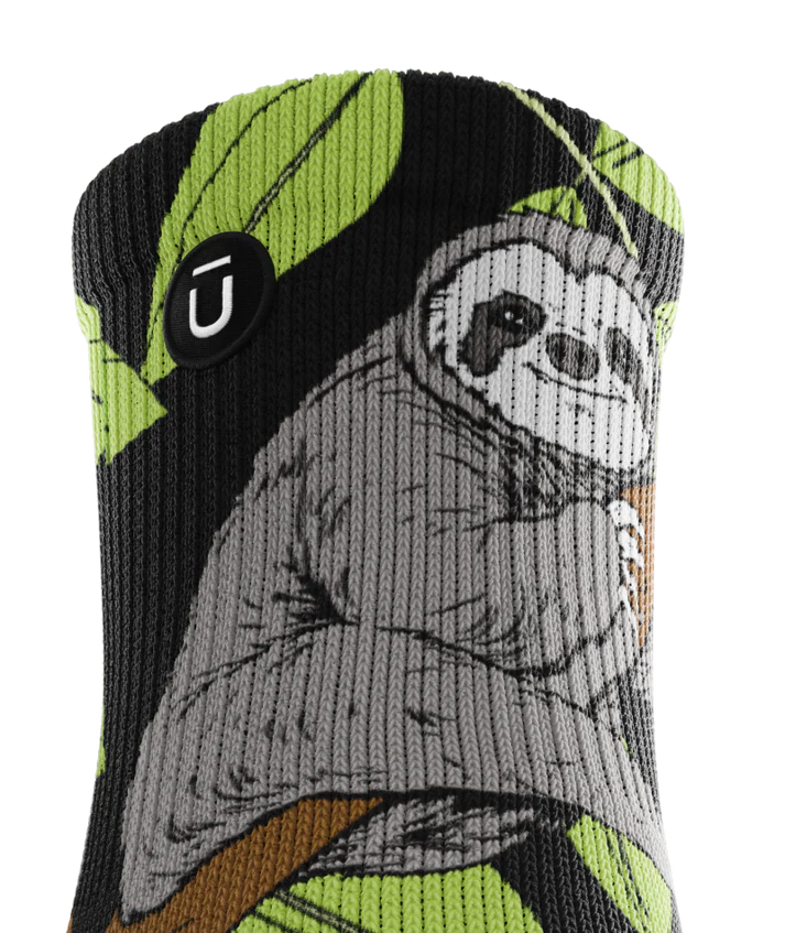 Top of cuff view of sock with sloths in trees on main part of sock. Small black circular patch with Outway logo on top third of cuff. 