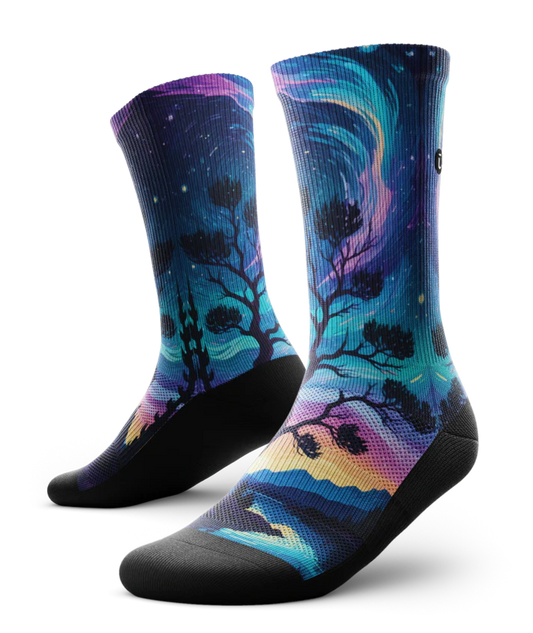 Multicolored pair of socks with colorful northern lights in the ski over a mountain lake with trees silhouetted.  