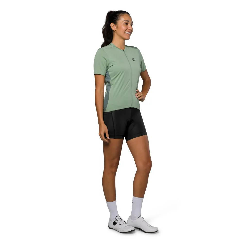 Studio image of model wearing a Pearl Izumi Sugar Jersey with a dark green Pearl Izumi logo on left chest area and dark green side panels.