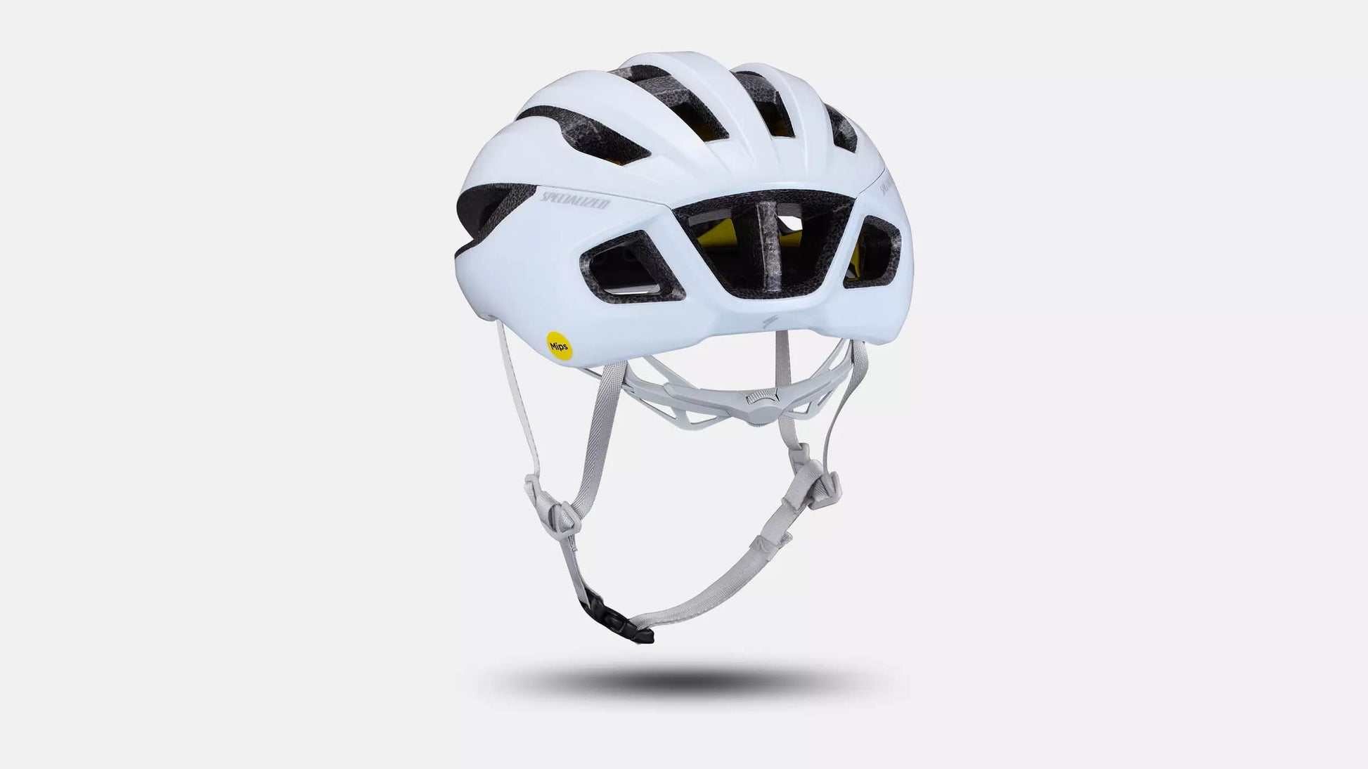 Back quarter angle studio image of a Specialized Loma white helmet back quarter angle studio image showing the white chin strap and fit adjustment dial along the base of the neck, five of the ventilation channels across the top of the helmet and three ventilation channels at the back of the helmet. 