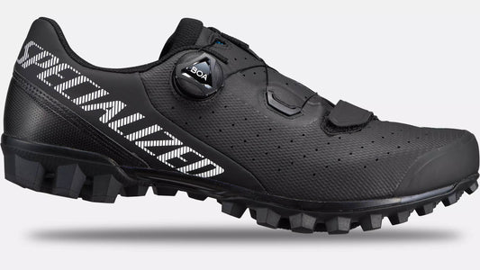 Studio image of the outer side of a Specialized Recon 2.0 black mountain bike show with white Specialized lettering extending from the top heel of the shoe down to the arch of the shoe, a black hook and loop closure across the toe and a black BOA dial.