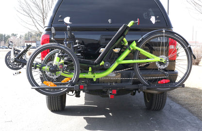 View of the Sunlite HRT-100 Trike Auto Rack for 2-inch Receivers mounted on the hitch on a pickup truck with a green Catrike on the rack in an outdoor setting.