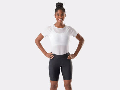Studio front view of a woman wearing black cycling shorts that extend about three inches above her knees.