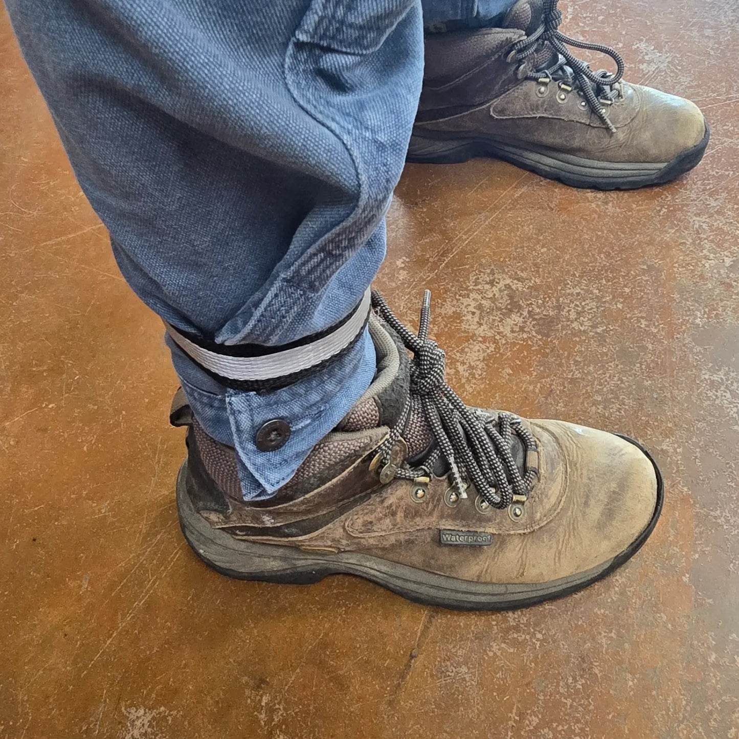 Closeup view of the Aardvark Ankle Biters Reflective Leg Band Black Single on a persons right leg.