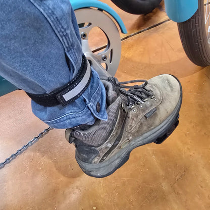 Closeup view of the Aardvark Ankle Biters Reflective Leg Band Black Single on a persons right leg while sitting on a bike.