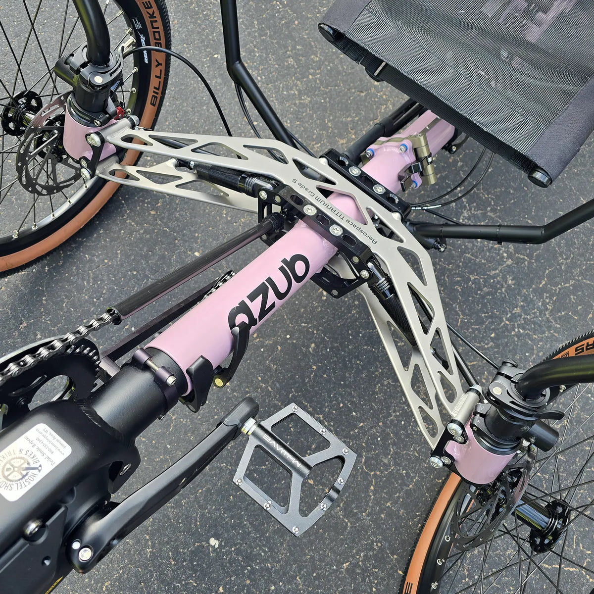 Closeup view of the front suspension and folding hinge on the Azub Demo Ti-Fly 20 Enviolo Shimano EP6 Pastel Violet Recumbent Trike in an outdoor setting.