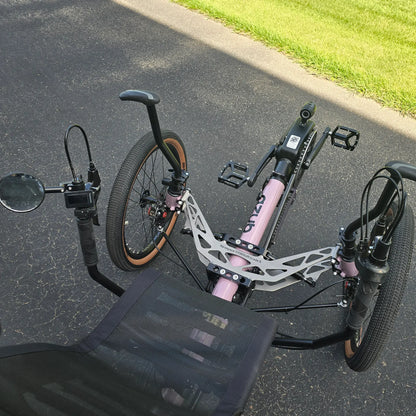 Closeup view of the front suspension, mirror, handlebars and controls on the Azub Demo Ti-Fly 20 Enviolo Shimano EP6 Pastel Violet Recumbent Trike in an outdoor setting.