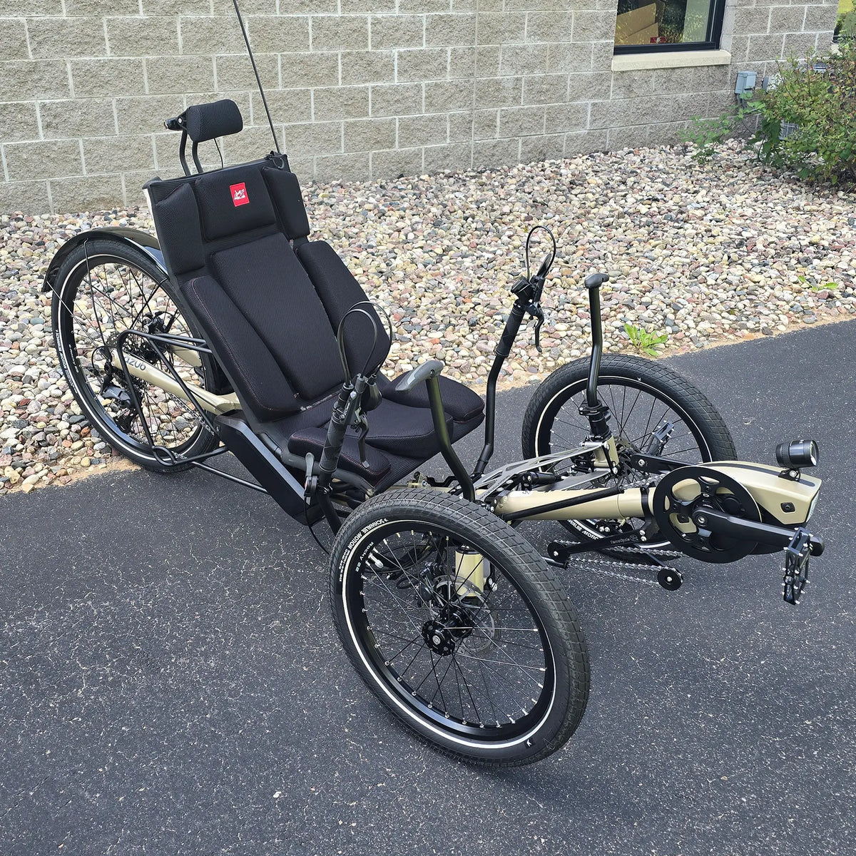 Angled side view of the Azub Demo Ti-Fly 26 Bosch Performance CX Dark Sand Recumbent Trike in an outdoor setting.
