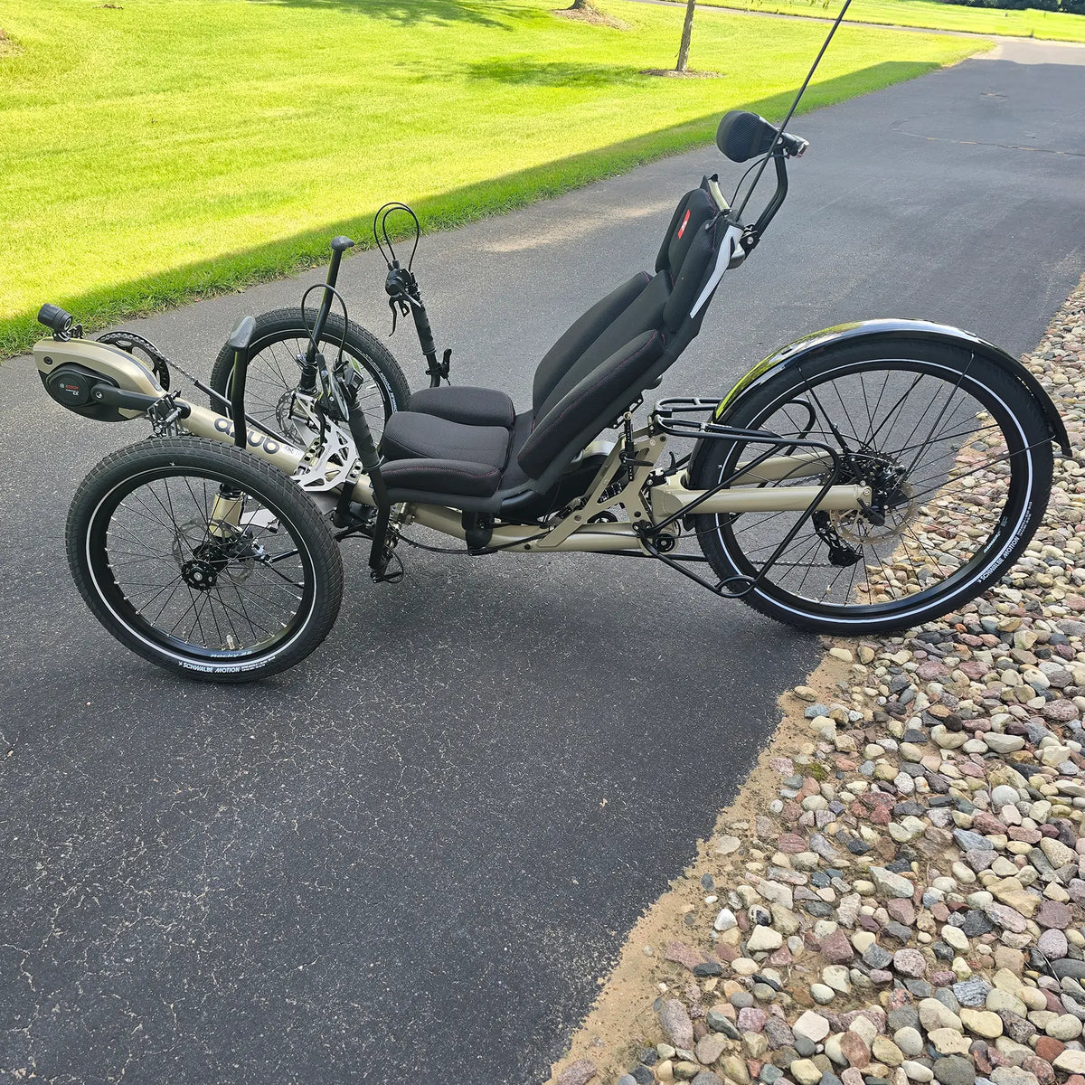 Non-drive side view of the Azub Demo Ti-Fly 26 Bosch Performance CX Dark Sand Recumbent Trike in an outdoor setting.