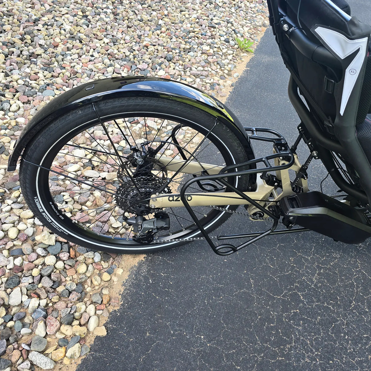 Closeup view of the mid rack, rear wheel, cassette, battery and rear derailleur on the Azub Demo Ti-Fly 26 Bosch Performance CX Dark Sand Recumbent Trike in an outdoor setting.