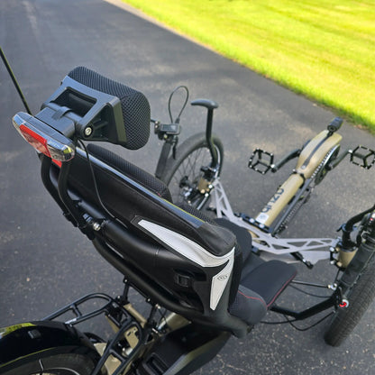 Closeup view of the neckrest and taillight on the Azub Demo Ti-Fly 26 Bosch Performance CX Dark Sand Recumbent Trike in an outdoor setting.