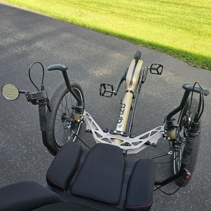 Closeup view of the mirror, grab handles, handlebars with controls and front suspension on the Azub Demo Ti-Fly 26 Bosch Performance CX Dark Sand Recumbent Trike in an outdoor setting.