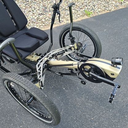 Closeup view of the headlight, Bosch motor, quick adjust and front suspension on the Azub Demo Ti-Fly 26 Bosch Performance CX Dark Sand Recumbent Trike in an outdoor setting.