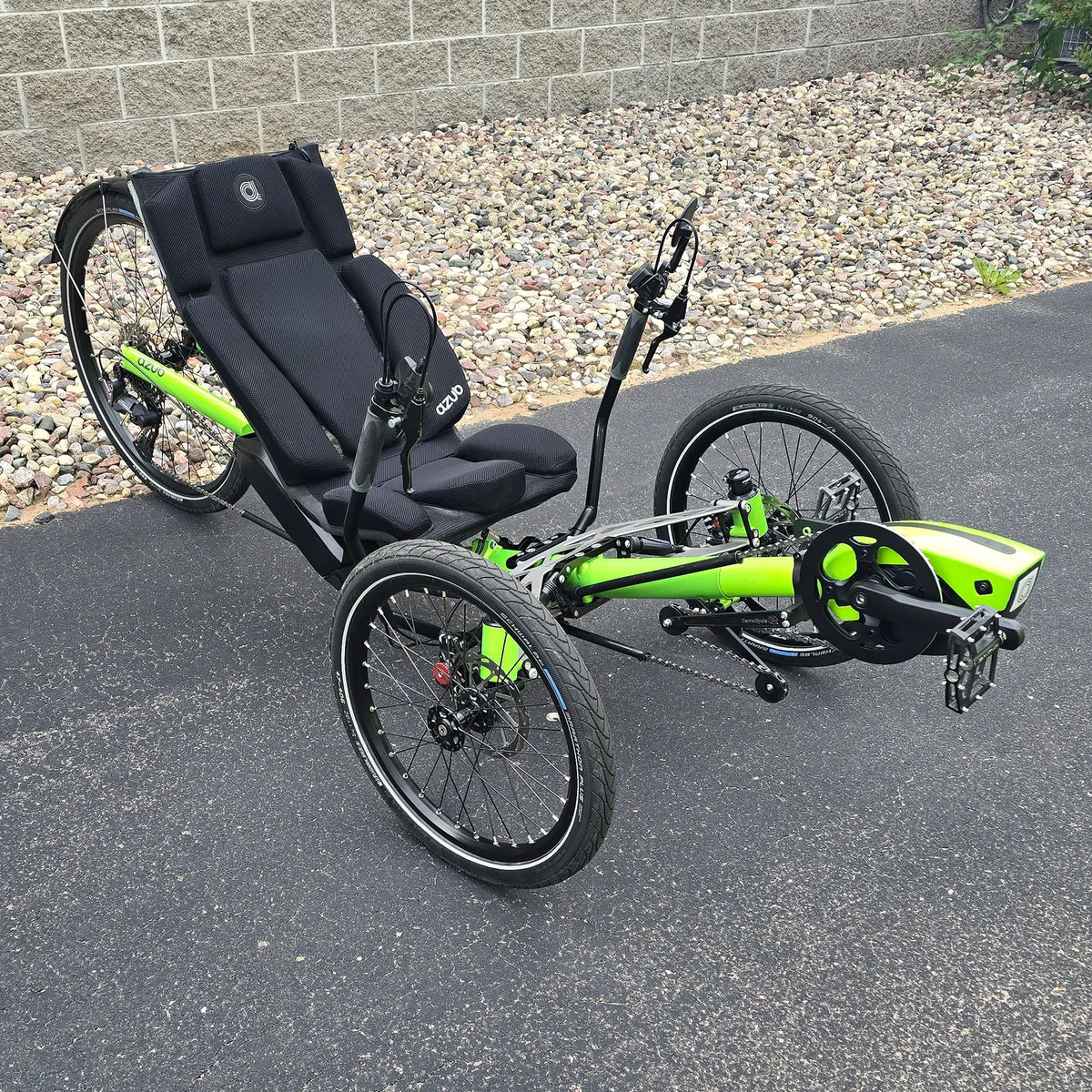 Angled side view of the Azub Demo Ti-Fly 26 Bosch Performance CX Lime Green Recumbent Trike in an outdoor setting.