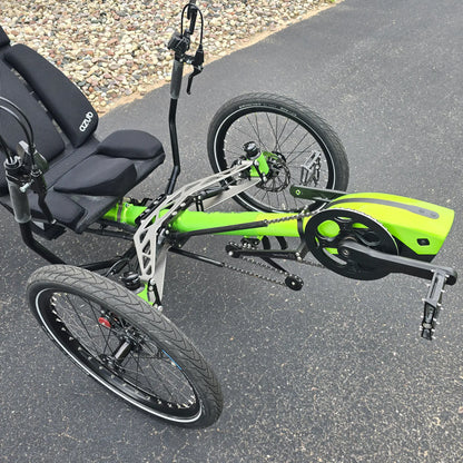 Closeup view of the Bosch motor, quick adjust and the front suspension on the Azub Demo Ti-Fly 26 Bosch Performance CX Lime Green Recumbent Trike in an outdoor setting.