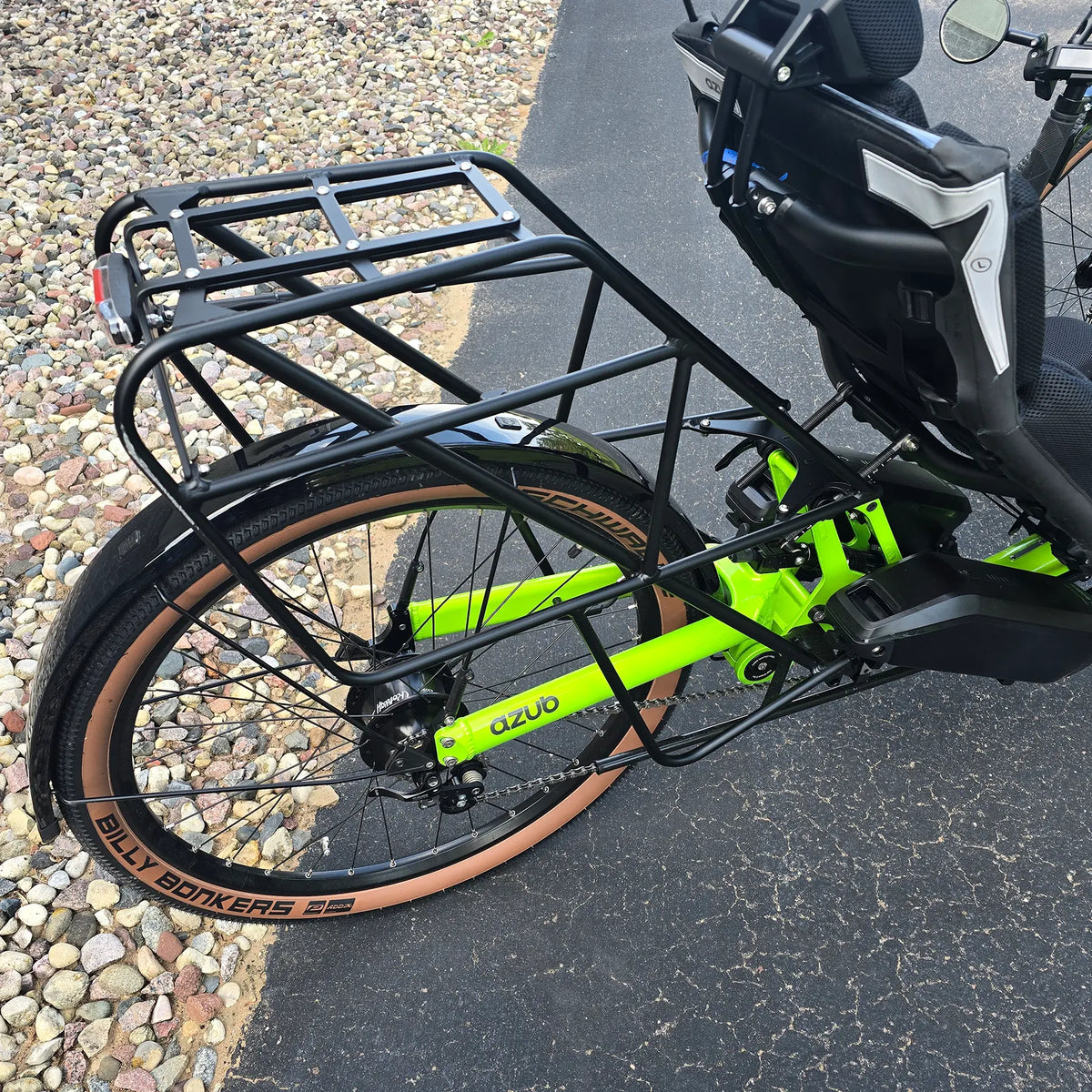 Closeup view of the rear wheel, rear fender, Rohloff hub, king rack and dual batteries on the Azub Demo Ti-Fly X Rohloff E14 Bosch Performance CX Dual Battery Lime Green Recumbent Trike in an outdoor setting.