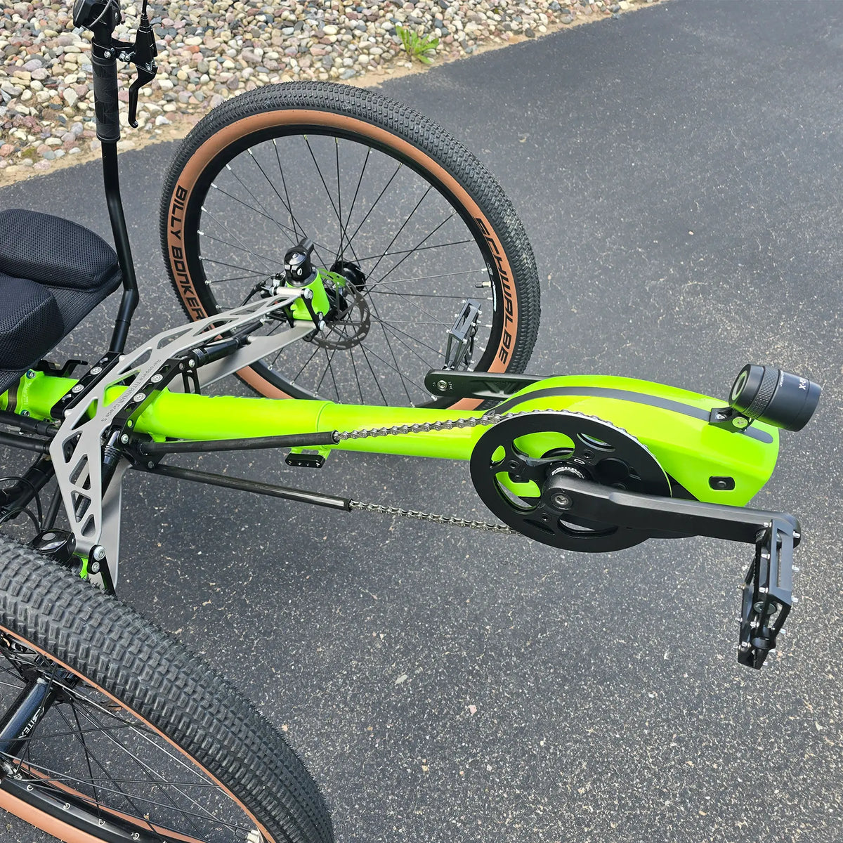 Closeup view of the front suspension and headlight on the Azub Demo Ti-Fly X Rohloff E14 Bosch Performance CX Dual Battery Lime Green Recumbent Trike in an outdoor setting.