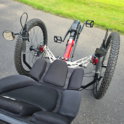 Closeup view of the front suspension, mirror and handlebars with controls on the Azub Demo Ti-Fly X Shimano EP6 Ruby Red Recumbent Trike in an outdoor setting.