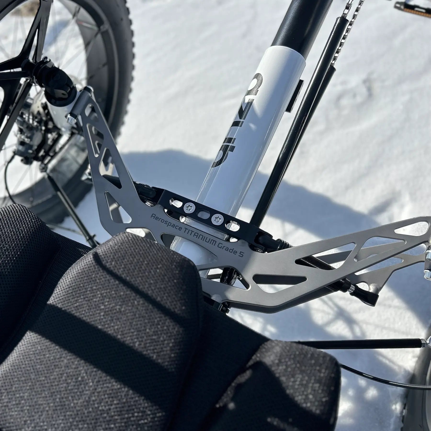 Closeup of the front suspension on the Azub Limited Edition Ti-Fly recumbent trike on a snowy path.