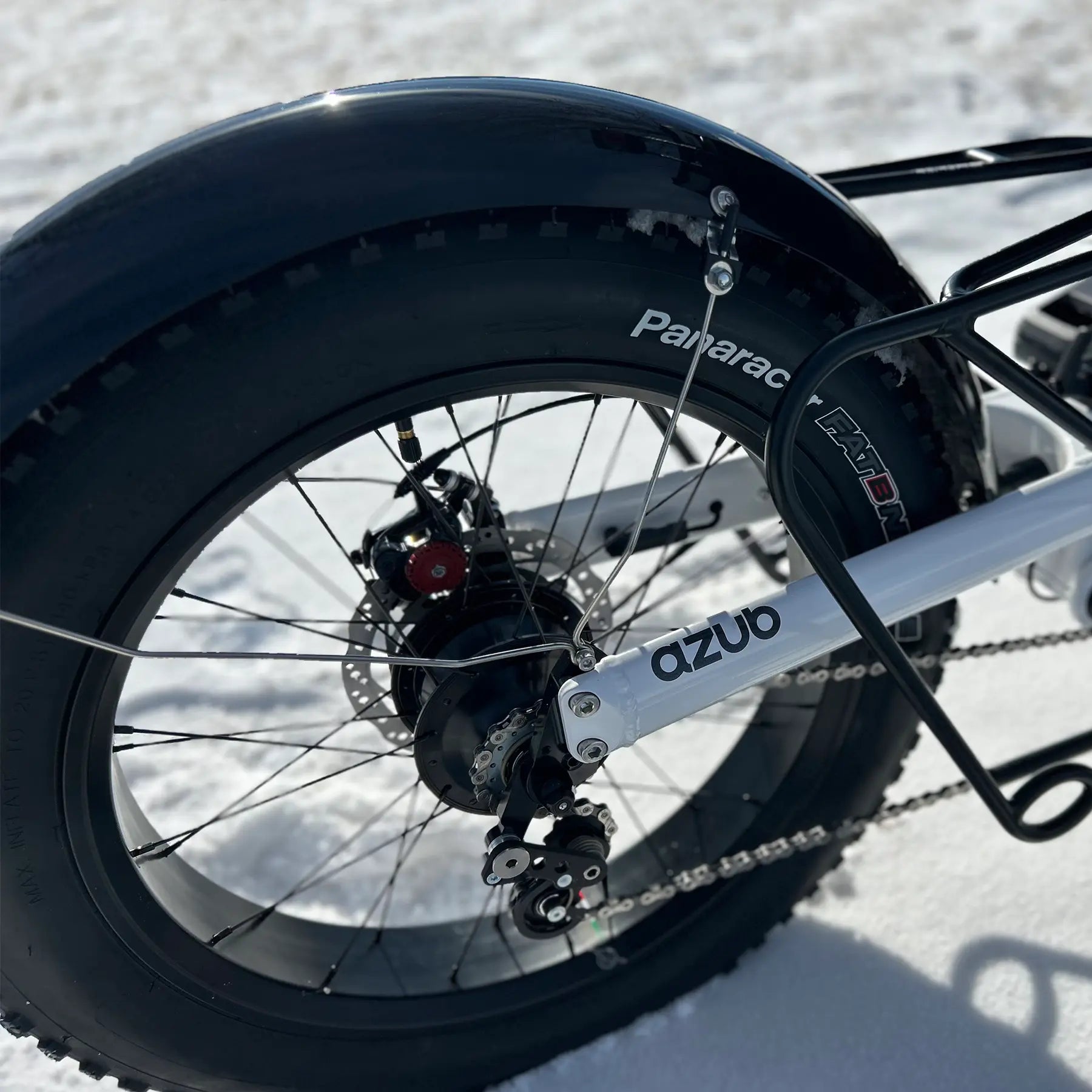 Closeup of the rear wheel on the Azub Limited Edition Ti-Fly recumbent trike on a snowy path.