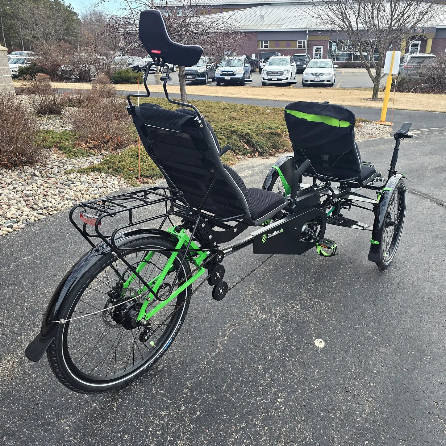 Angled rear view of the BamBuk Independent Bosch Performance CX Recumbent Tandem Trike in the Hostel Shoppe parking lot.